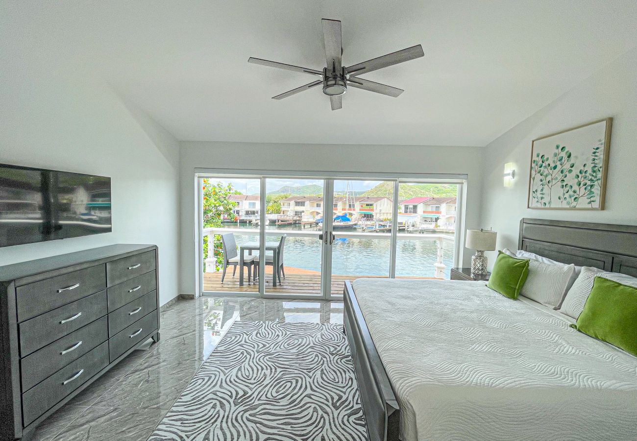Spacious bedroom with en-suite bathrooms and private balcony at Jolly Harbour villa rentals