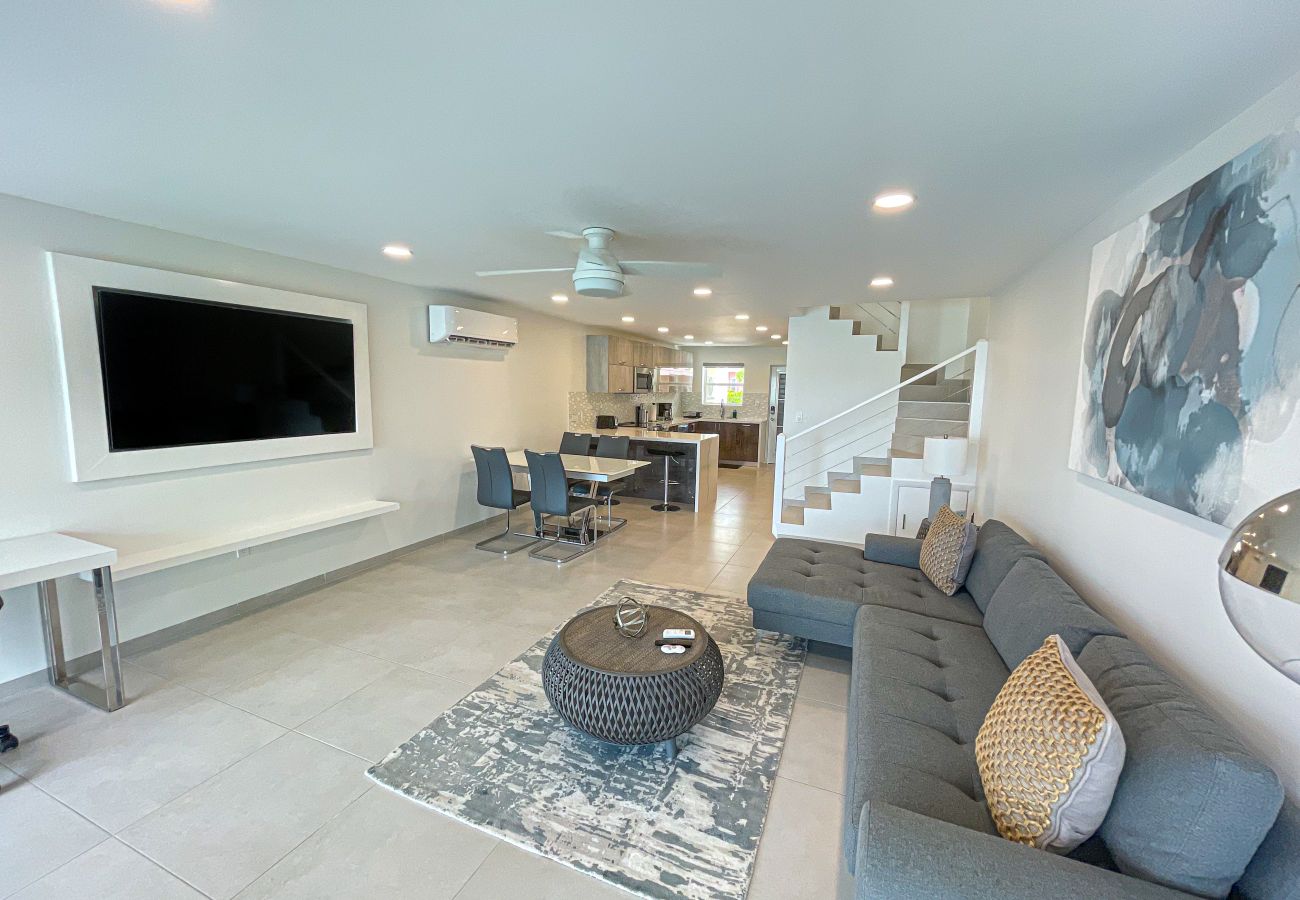 Two Bedroom Property with a built-in flat screen TV, stylish L-shaped sofa and a workspace with an amazing ocean view