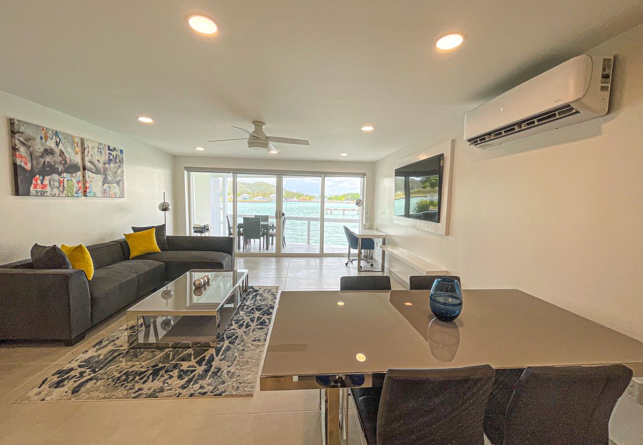 Beautiful Waterfront villa with an indoor dining table, an L-shaped sofa, and a work desk with an amazing waterfront view