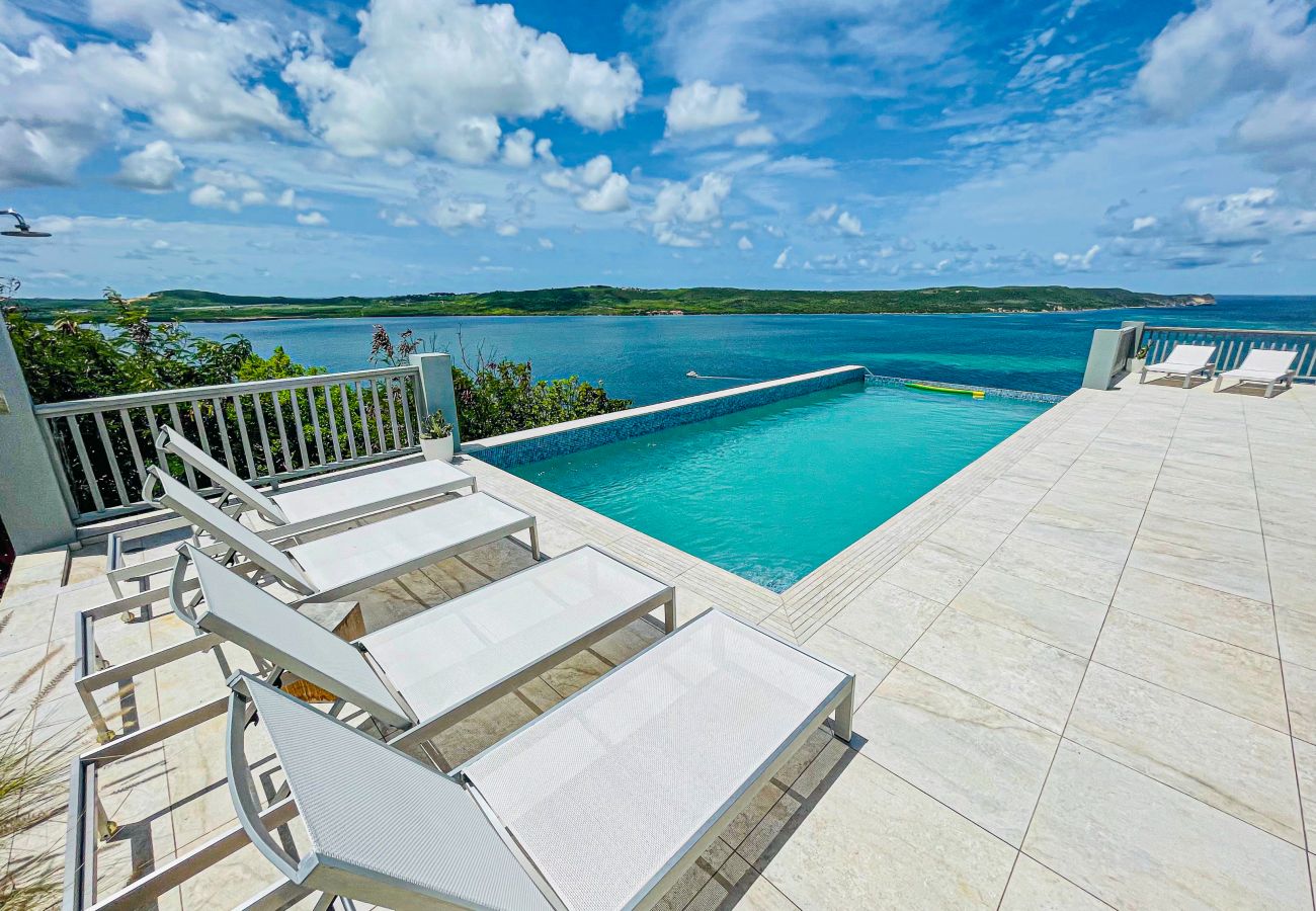 English Harbour villa rentals, sun loungers, infinity edge pool with ocean views 