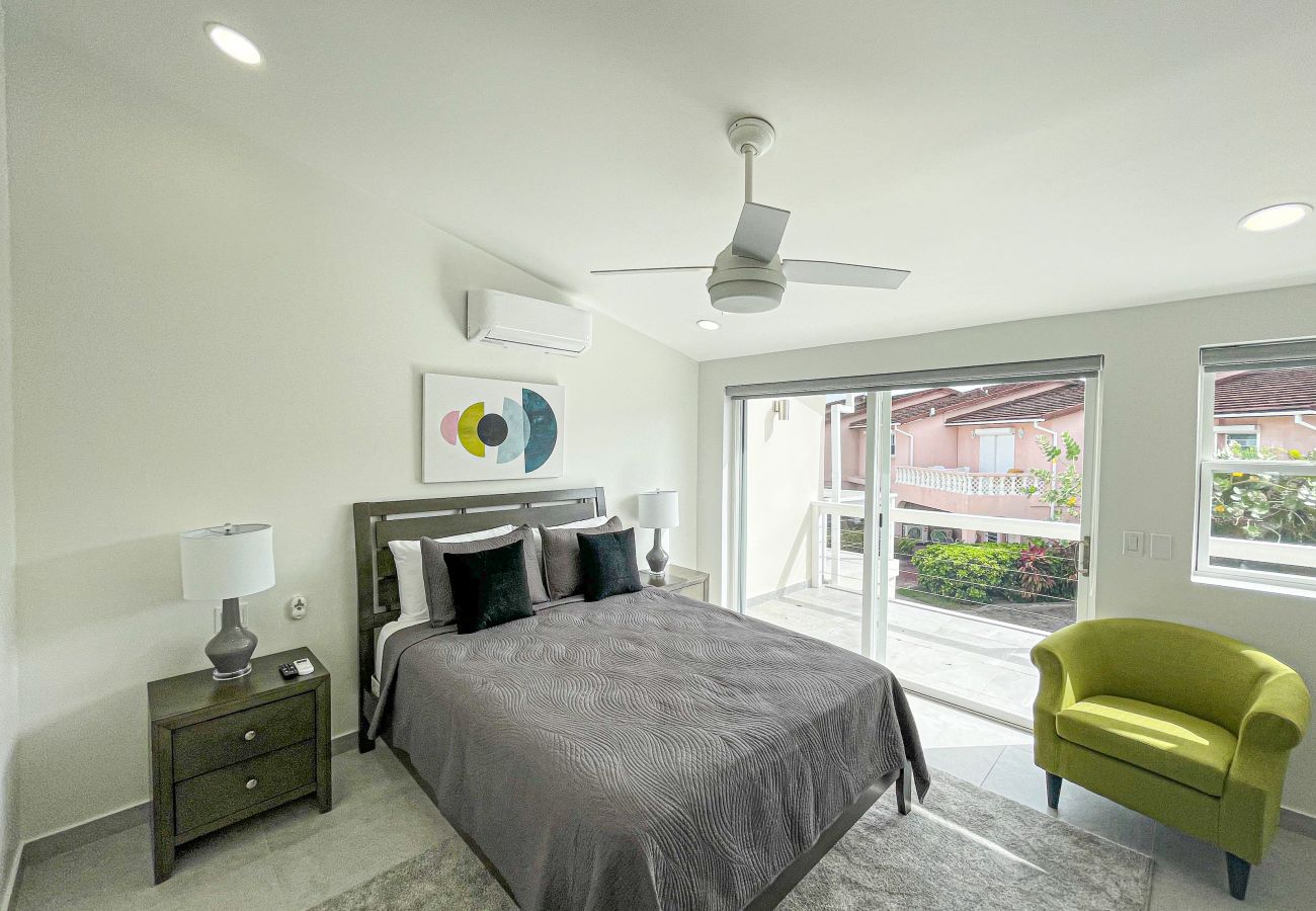 Spacious one bedroom with queen-sized bed, adequate closet space, and a private balcony at Jolly Harbour 