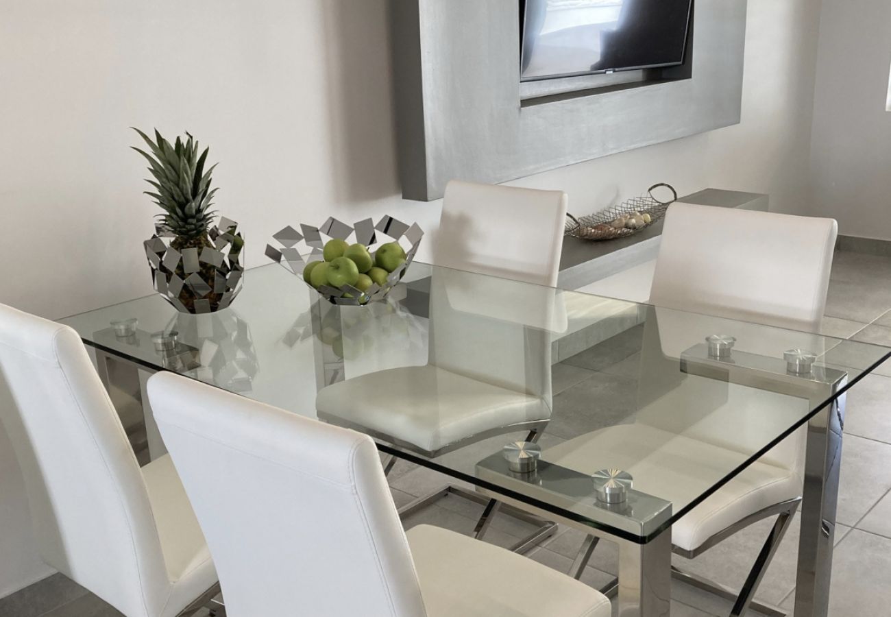 Modern waterfront villa with a chic glass metal dining table ,private balcony  with amazing views at Jolly Harbour 