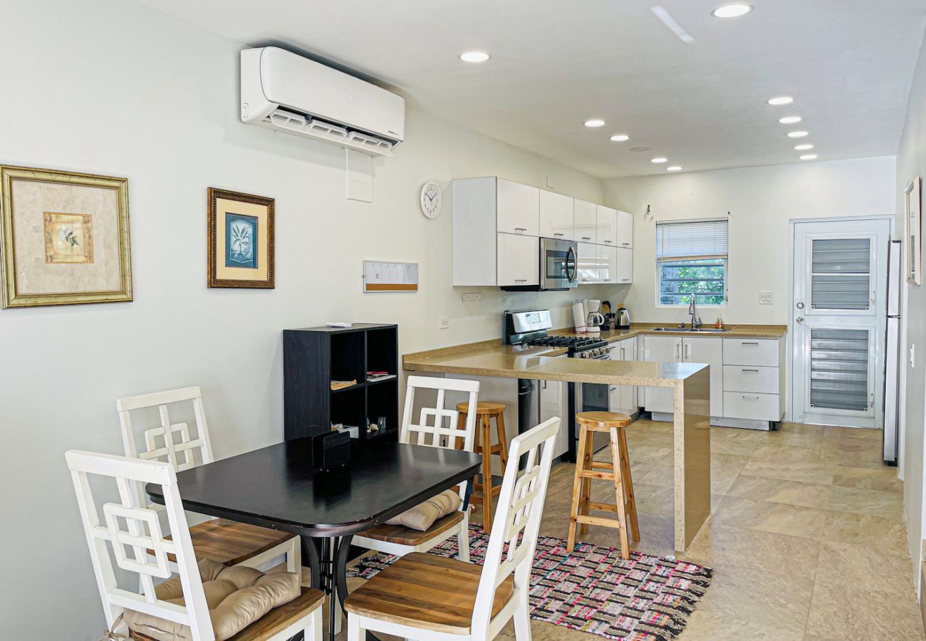 Spacious kitchen with stainless steel appliances,, dining area, and a lounge at Jolly Harbour villa rentals