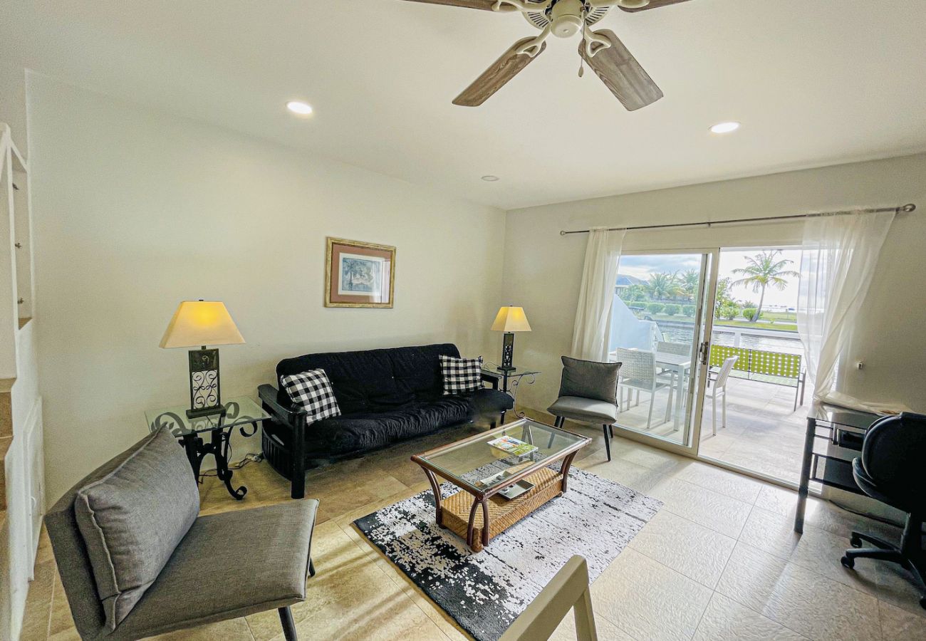 Stunning living room with partially shaded waterfront terrace and sunset views at Jolly Harbour villa rentals