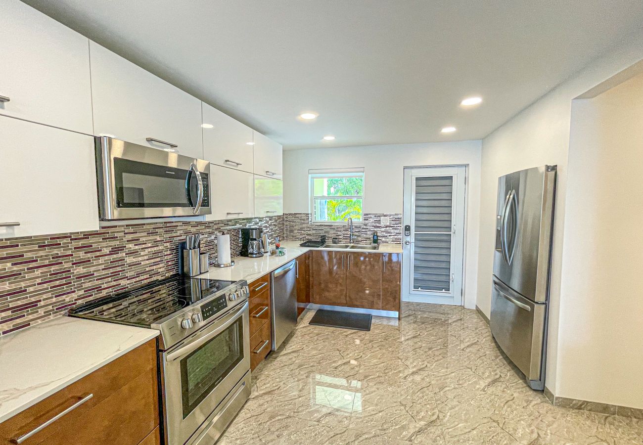 Open-plan kitchen, with a double sink,dual voltage outlets and a breakfast bar with two seats at Jolly Harbour villa rentals