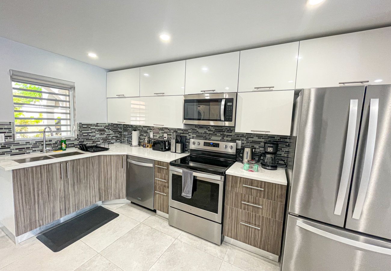 Modern L-shaped kitchen with Corian countertops, Large double fridge with freezer at Jolly Harbour Villa rentals