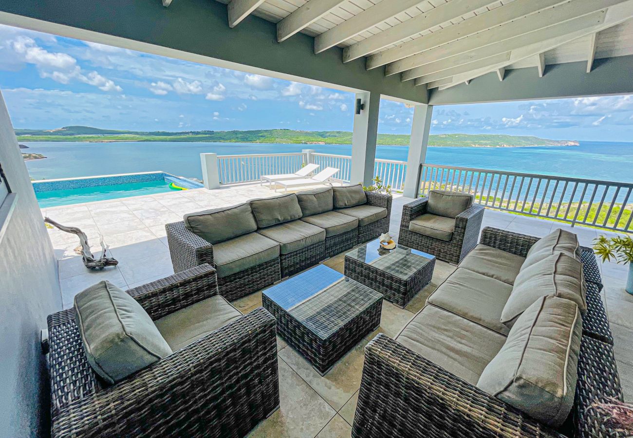 Spectacular ocean views with infinity edge pool, sun loungers and outdoor dining at English Harbour Villa Rentals